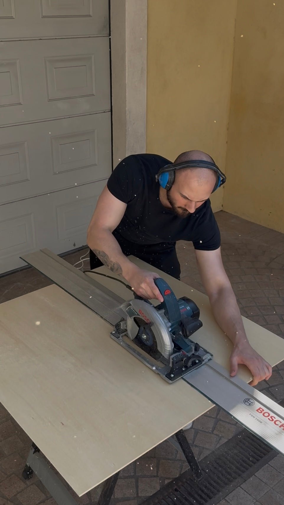 Bastien découpe une planche de tilleul à la scie dans l'atelier Baby in Wood